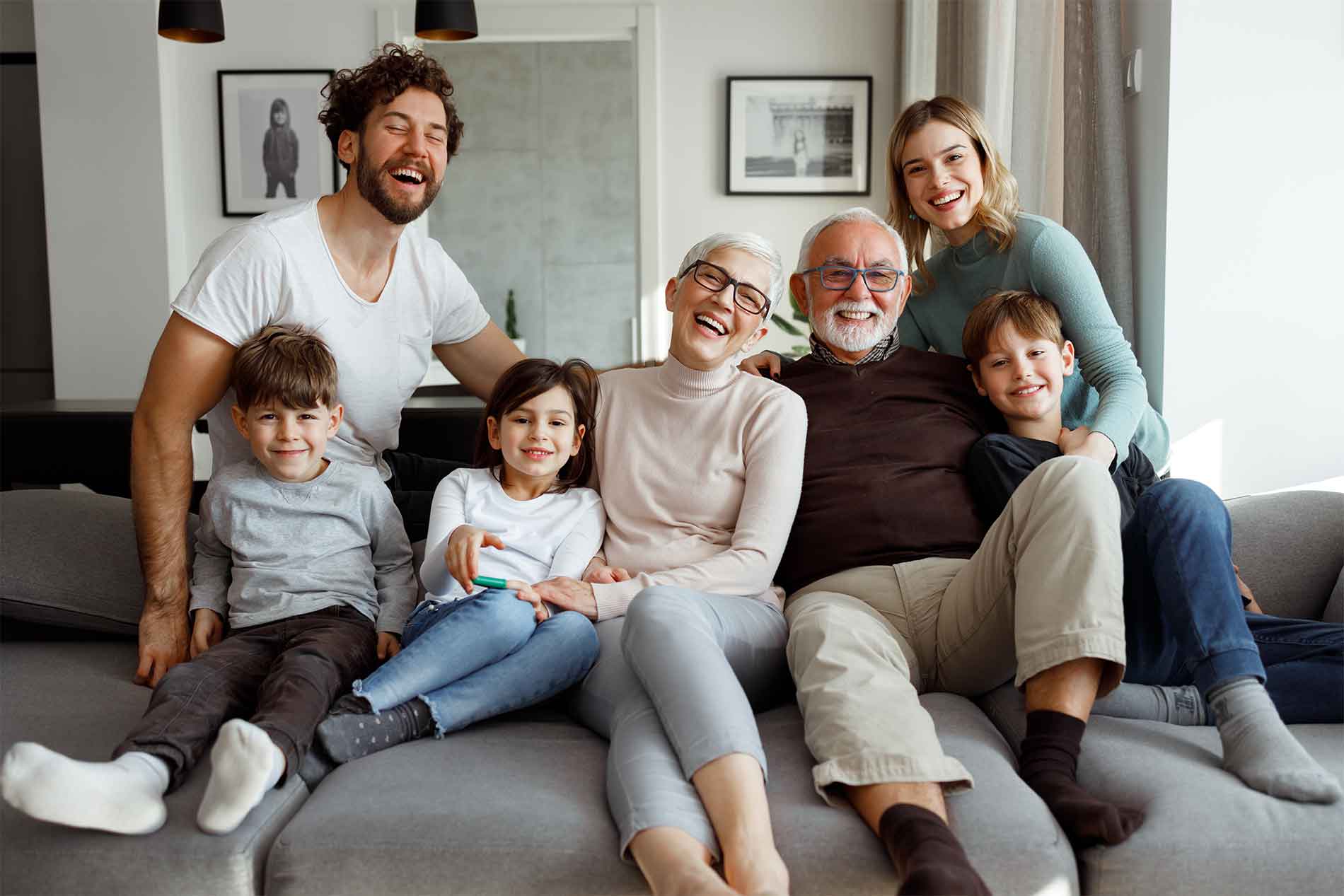 Multi-generational family sitting on the couch sharing a laugh.